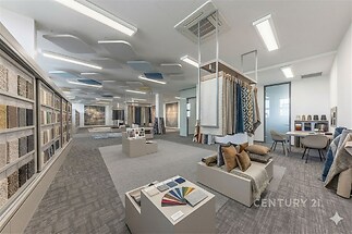 Obchodní prostor s moderním designem, světlé osvětlení a kobercové vzory. Vhodné pro showroom s optimálním využitím prostoru.
