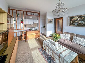 Světlý retro obývací pokoj s orientací na jih propojený s kuchyní.