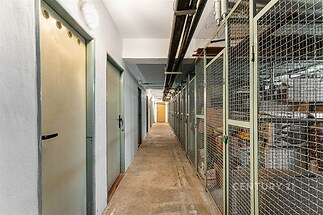 Suterénní úložný prostor s betonovou podlahou a drátěnými klecemi, vhodný pro skladování, v dobře udržovaném stavu.