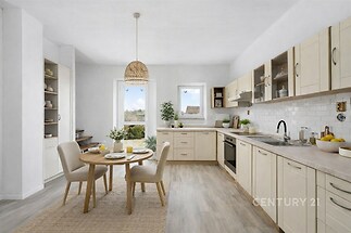 Světla kuchyň s dřevěnou podlahou, moderními vestavěnými skříněmi a velkými okny, která zajišťují dostatek přirozeného světla.