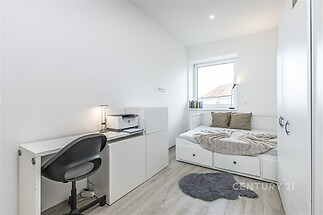 Světlý dětský pokoj s moderním nábytkem, vestavěné skříně poskytují úložný prostor, elegantní parketová podlaha dodává útulnou atmosféru.