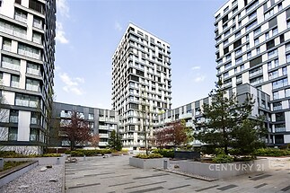 Moderní bytový komplex s elegantní fasádou, velkými okny a prostornými terasami, ideální pro městské bydlení.