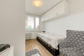 Světlá ložnice s parketovou podlahou, vestavěné skříně, moderní nábytek, velká okna propouštějící přirozené světlo