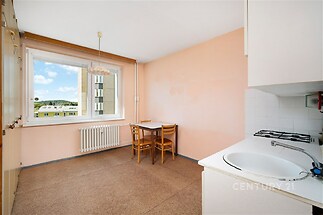 Kuchyň s dlažbou, velkým oknem a vestavěnými skříněmi, jednoduchý design, ideální pro rekonstrukci a modernizaci prostoru.