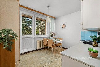 Jídelní kout s velkými okny, původní dřevěné obložení a světlá dlažba, světlý interiér, moderní osvětlení.