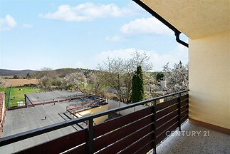 Balkón s krásným výhledem, moderní zábradlí, venkovní dlažba. Ideální pro relaxaci v klidném prostředí s výhledem na přírodu.
