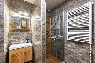 Moderní koupelna s dřevěným nábytkem, sprchovým koutem a keramickými obklady. Stylová a rekonstruovaná s topným žebříkem.