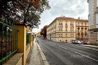Historická ulice s dlážděným chodníkem a řadovými činžovními domy, klidná lokalita v blízkosti centra města, vhodná investiční příležitost