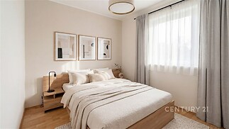 Světlá ložnice s parketovou podlahou, moderním nábytkem a velkým oknem, které umožňuje dostatek přirozeného světla.