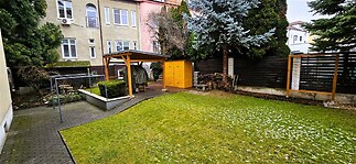 Zahrada s udržovaným trávníkem, dřevěným altánem a dřevěným plůtkem, ideální pro odpočinek, soukromý pozemek v klidné lokalitě.