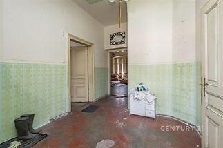 Vstupní hala s retro designem, dlažba a původní dveře, světlé stěny se vzorem, prostorný vstup do dalších pokojů.