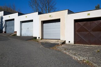 Garáž s moderní kovovou vraty, asfaltová příjezdová cesta, dobrý stav, ideální pro bezpečné parkování.