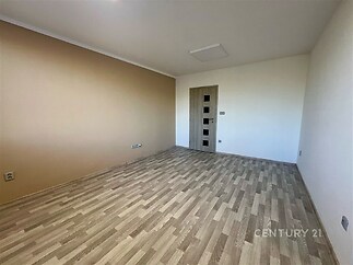 Prázdný pokoj s parketovou podlahou, moderní dveře a světlé stěny, ideální pro osobní úpravy a dekorace.