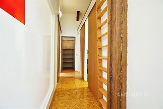 Úzká chodba s dřevěným obložením a dveřmi, parketová podlaha, světlý interiér s moderním designem, vestavěné osvětlení