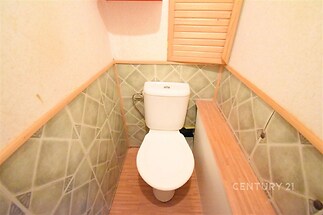 Toaleta s dlažbou a dřevěnými prvky, útulný interiér, dobrý stav.