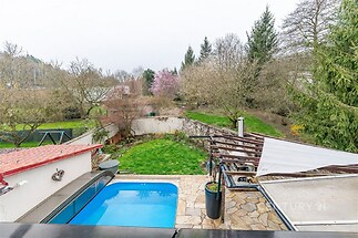 Zahrada s venkovním bazénem, kamenná dlažba a vzrostlé stromy poskytují soukromí. Klidná lokalita ideální pro relaxaci.