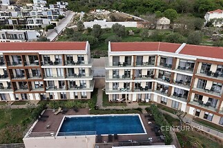 Moderní rezidenční komplex s venkovním bazénem, terasami a zelení, ideální pro luxusní bydlení. Kvalitní architektura a klidné okolí.