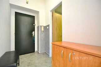 Vstupní hala s dlažbou, vestavěnými skříněmi a moderními dveřmi, nabízí praktické úložné řešení a elegantní design.