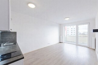 Světlý obývací pokoj s moderní parketovou podlahou, velká okna a světlá výmalba dodávají prostoru vzdušnost a příjemnou atmosféru.