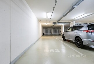 Podzemní garážové stání s hladkou betonovou podlahou a moderním osvětlením, ideální pro bezpečné parkování.