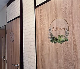 Světlá chodba s moderními dveřmi, dekor dřeva, cihlové obklady na stěnách, dobře udržovaný prostor.