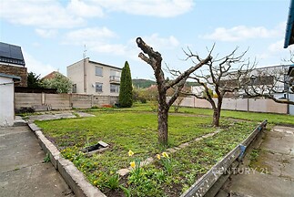 Zahrada s trávníkem, betonovou terasou a vzrostlými stromy, ideální pro úpravy dle vlastních představ, nachází se ve vilové čtvrti.