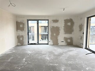 Prázdný pokoj s betonovou podlahou, velká okna zajišťují dostatek světla, ideální pro rekonstruování podle vlastních představ.