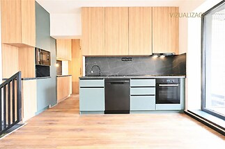 Moderní kuchyň s parketovou podlahou, vestavěnými skříněmi a černými spotřebiči, světlý prostor se stylovými dřevěnými prvky.