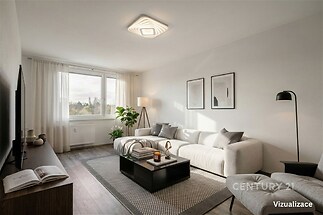 Světlý obývací pokoj s moderní sedačkou, velkými okny a dřevěnou podlahou, minimalistický styl a elegantní dekorace.