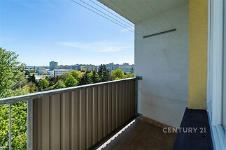Balkon s výhledem na město, dlažba na podlaze, prostorný a světlý, ideální pro relaxaci.