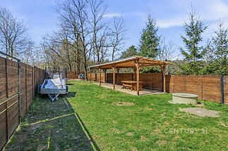 Zahradní prostor s dřevěným altánem, zatravněný povrch, oplocení z dřevěných latí, skvělý pro relaxaci, ideální pro rodinné aktivity.