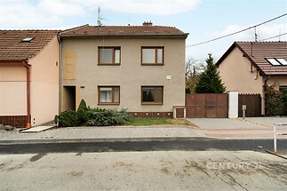 Dvoupodlažní rodinný dům s klasickou fasádou, garáž, předzahrádka a příjezdová cesta dlažbou, klidná lokalita.