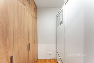 Úložný prostor s vestavěnými skříněmi a moderními dřevěnými dveřmi, nabízející efektivní využití prostoru.