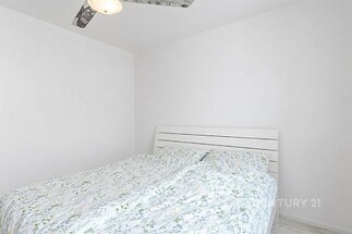 Světlá ložnice s dřevěnou postelí a jednoduchým bílým designem, moderní styl, světlé stěny a minimalistický vzhled