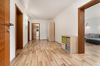 Prostorná chodba, světlý interiér s parketovou podlahou, moderní dřevěný nábytek, jednoduchý styl, vestavěné skříně pro úložný prostor