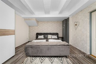 Prostorná ložnice s parketovou podlahou, moderní vestavěné skříně a stylové dekorativní stěny, útulný a světlý interiér.