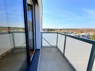 Balkón s moderní kovovou podlahou, skleněné zábradlí, výhledem na okolní prostředí, ideální pro relaxaci.