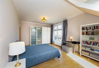 Prostorná ložnice s parketovou podlahou, velkými okny a vestavěnými skříněmi nabízí moderní komfort a dostatek světla.