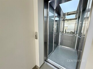 Moderní výtah s nerezovými stěnami a velkým střešním světlíkem, poskytující dostatek přirozeného světla, ideální pro pohodlný přístup.