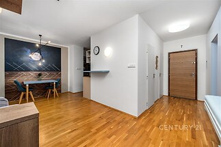 Chodba s moderním stylovým designem, parketová podlaha, kvalitní dřevěné dveře, světlé stěny, elegantní osvětlení, prostor pro dekorace.