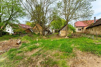 Velký stavební pozemek s trávou a stromy, vhodný pro rekonstrukci či novou výstavbu, nachází se v klidné části obce s dostupností inženýrských sítí