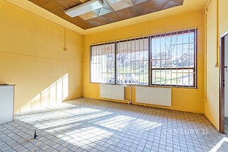 Světlá místnost s velkými okny a dlažbou, nabízí výhled do zahrady. Vyniká moderním stropním obložením a novými radiátory.