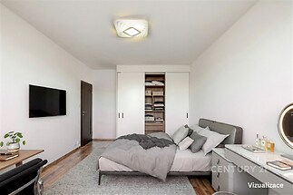 Prostorná ložnice s vestavěnými skříněmi, moderní nábytkem a parketovou podlahou, světlá atmosféra vhodná pro pohodlný odpočinek.