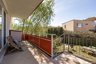 Balkon s dlažbou nabízí výhled na zahradu, moderní zábradlí a dostatek prostoru pro venkovní posezení, ideální pro relaxaci na čerstvém vzduchu.