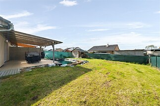 Zahrada s terasou, moderní dlažba, dřevěná pergola, udržovaný trávník, klidná lokalita, ideální pro rodinný relax.