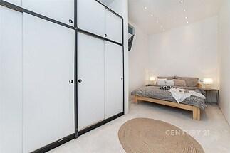 Prostorná ložnice s vestavěnými skříněmi, moderním osvětlením a kobercem, nabízí útulný a čistý design ideální pro relaxaci.