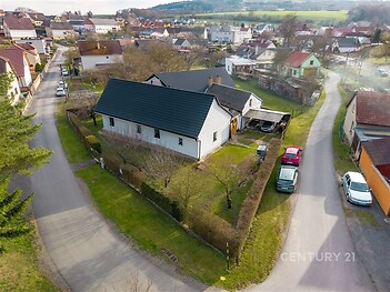 Útulný rodinný dům s dřevěnou střechou, nově rekonstruovaný, obklopený prostornou zahradou v klidné venkovské čtvrti.