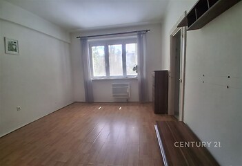 Světlý obývací pokoj s parketovou podlahou, velkými okny a bílými stěnami, moderní interiér vhodný k okamžitému nastěhování