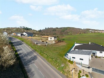 Novostavba rodinného domu s moderními prvky, nacházející se u klidné silnice na okraji vesnice, obklopená přírodou a panoramatickým výhledem.