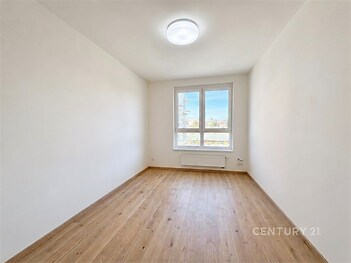 Světlá ložnice s parketovou podlahou, velkými okny a moderním osvětlením, ideální pro rekonstrukci nebo nový design.